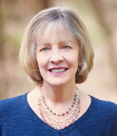 Photo of author Gail Ward Olmsted in a tiered bead necklace and royal blue dress.