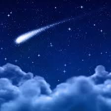 A dark-blue, realistic image of a comet, on background of stars, shooting across the sky above a bank of fluffy clouds